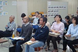 椅子に腰かけて話を聞いている市民討議会参加者の写真