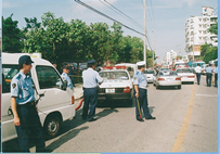 道路にパトカーが停まっていて警官達が立っている写真