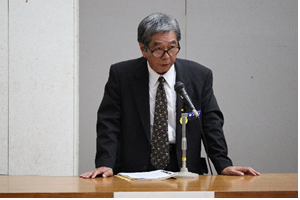演台に両手を置いてマイクの前で話をしている森田氏の写真