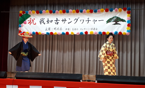 花笠を被った男性物の着物姿の女性と黄色に模様がはいった着物姿の女性2人で踊っている写真