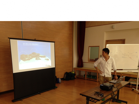 プロジェクターを使って説明をしている大学生の写真