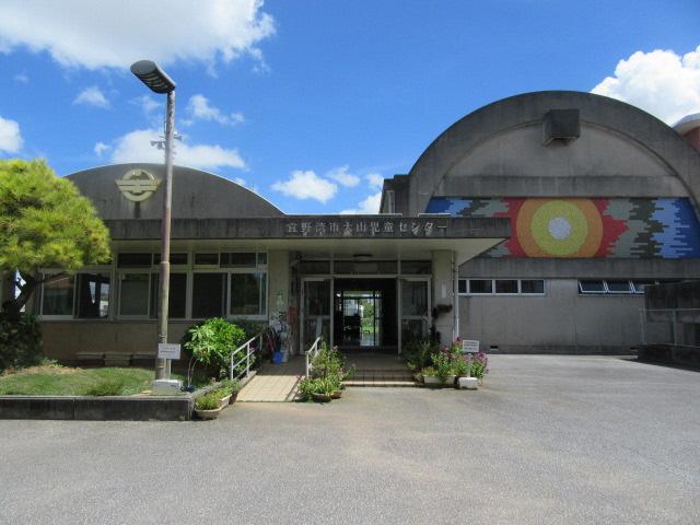 正面入り口前にスロープと階段のある大山児童センター外観写真