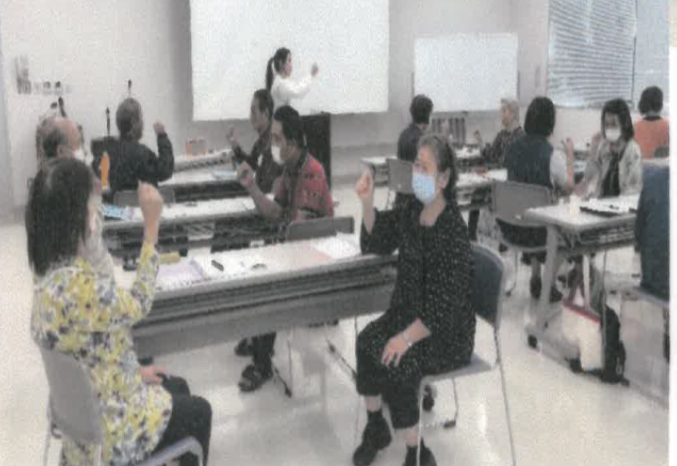 はごろも長寿大学。受講者座って、じゃんけんをしている。