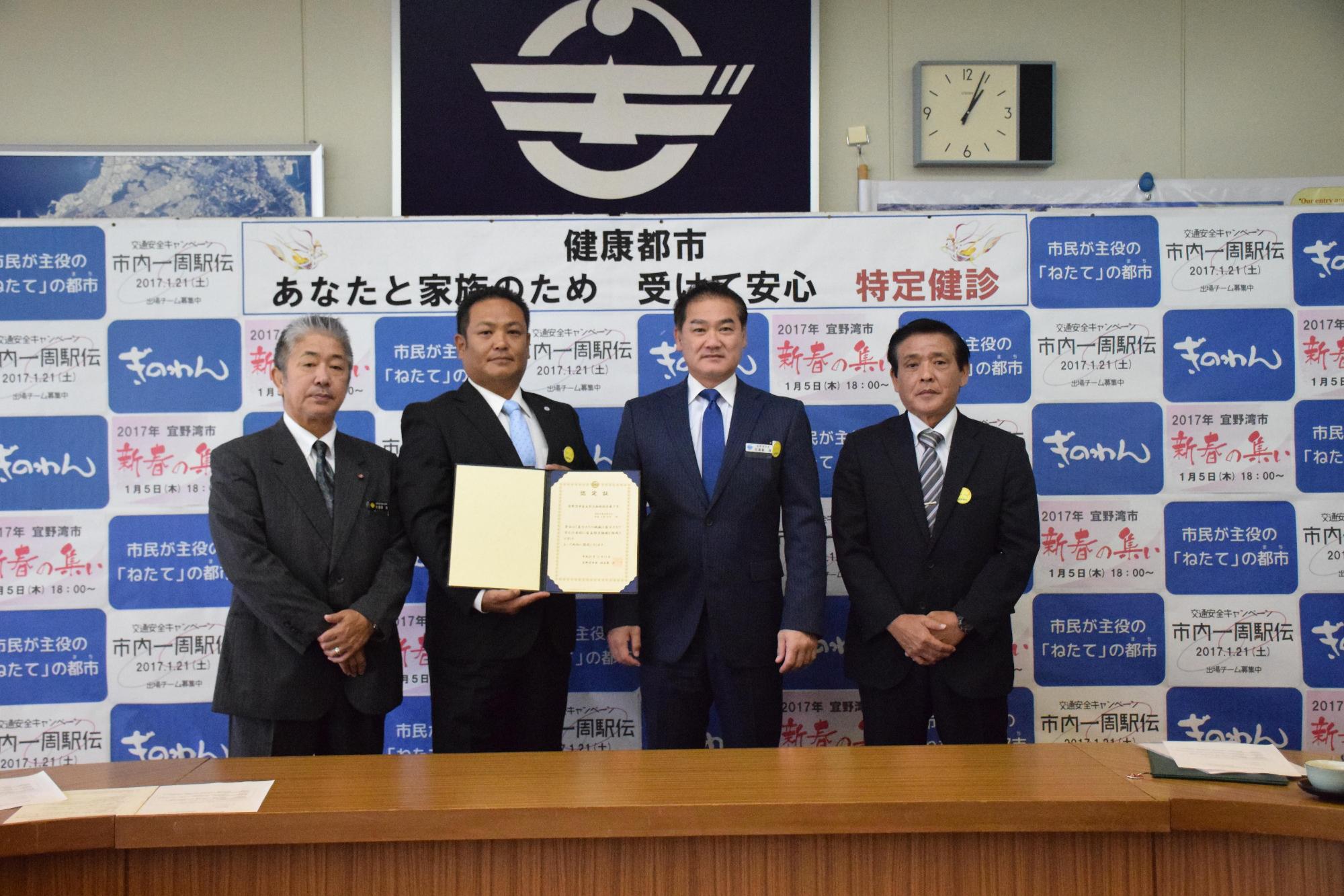 市長と自主防災組織認定証を持った男性と関係者2名で記念撮影をしている写真