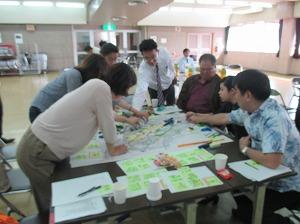 模造紙に書かれた地図を7名の方が中心に集まり作業をしている写真