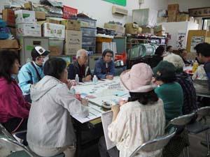 会議室にて10名ほどの参加者が話し合いをしている写真
