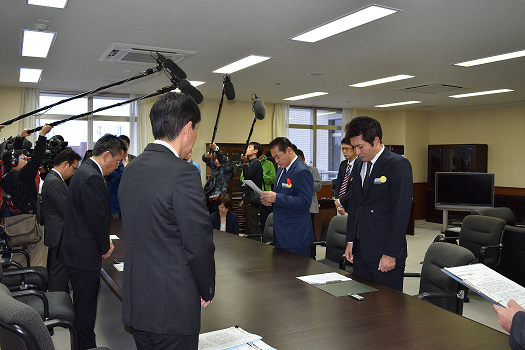 報道陣に囲まれた会議室で市長が抗議要請の文書を読み上げている写真