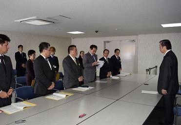 関係機関の方と向き合い、うち前列に6名の関係者が並び、中央で市長が文書を読み上げている写真