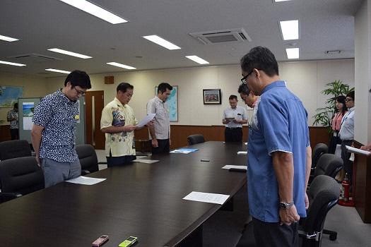 会議室で一同が起立し関係者へ向けて抗議・要請文章を読んでいる写真