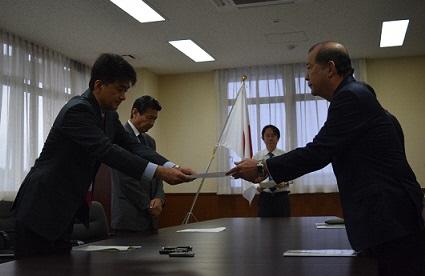関係者の方3名が向かい合って立ち抗議・要請書を手渡している写真