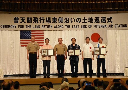 外国の方3名と日本の代表者3名の皆さんが舞台上に並んで記念撮影をしている写真