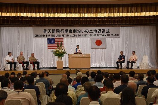 舞台上には6名の席が設けられ、舞台下には多くの市民が参列している中式典が行われている会場内の写真