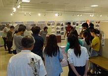 展示室の中央に集まった来場者が案内を聞いている写真