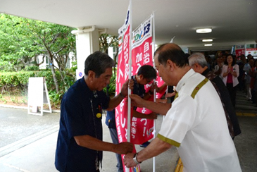 宜野湾市長と森田会長によるのぼり旗の贈呈を行っている写真