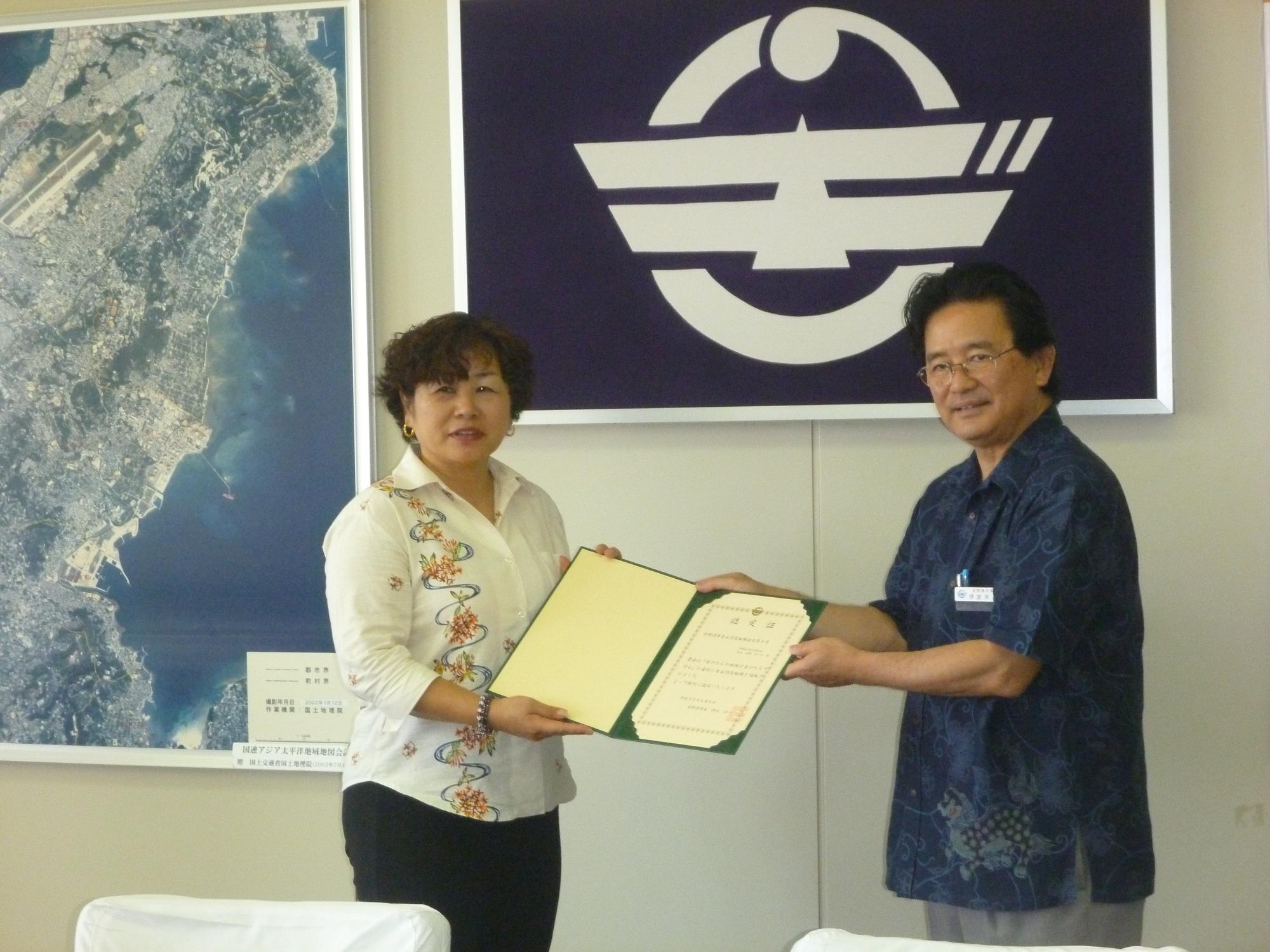 宜野湾市市長が伊佐区自治会長へ、認定証を授与している写真