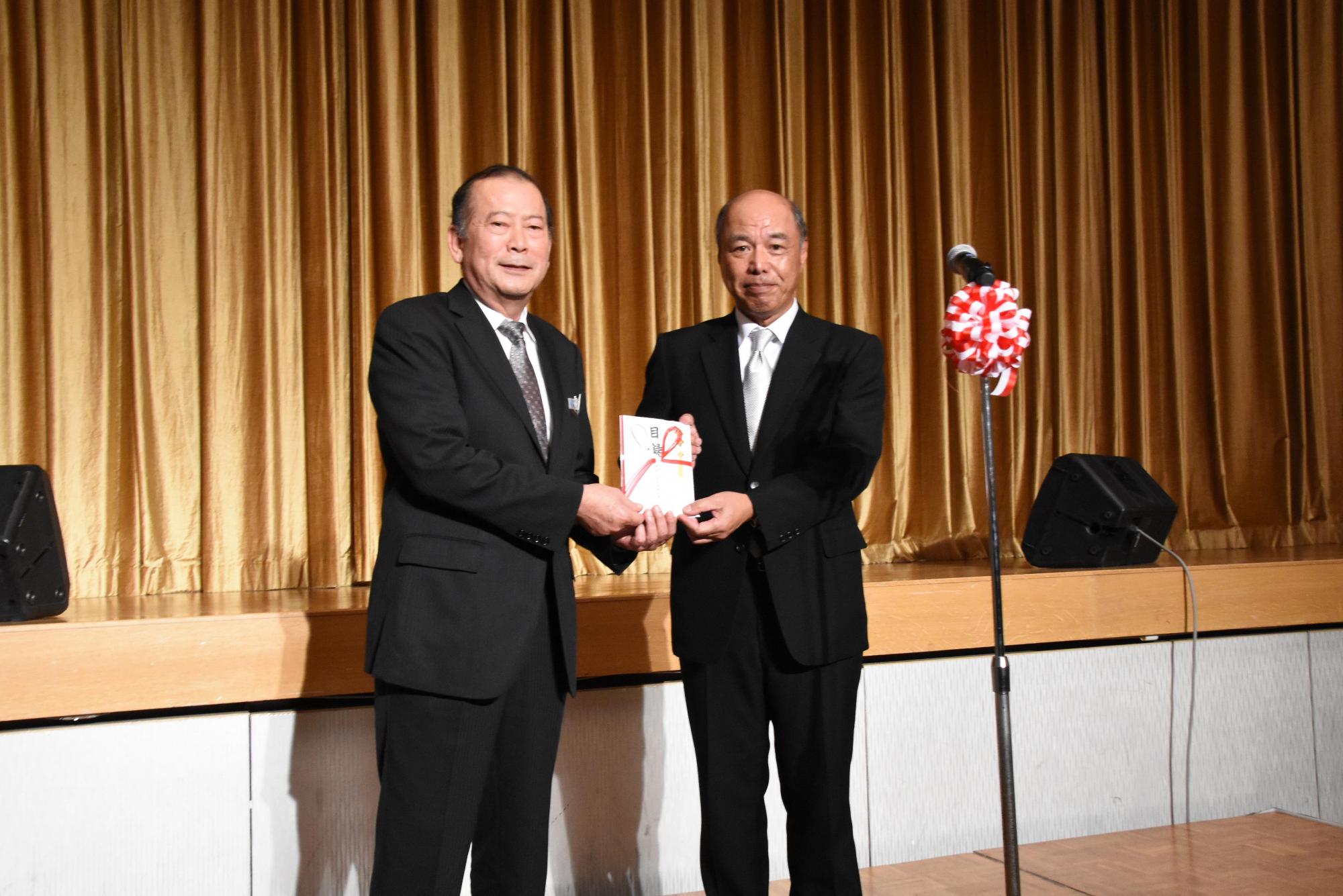 松川市長と大野 和也さんが目録を持ち、笑顔で写っている写真