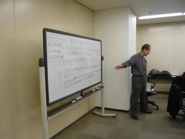 池田 孝之講師が、右手でホワイトボードを差し講演されている写真