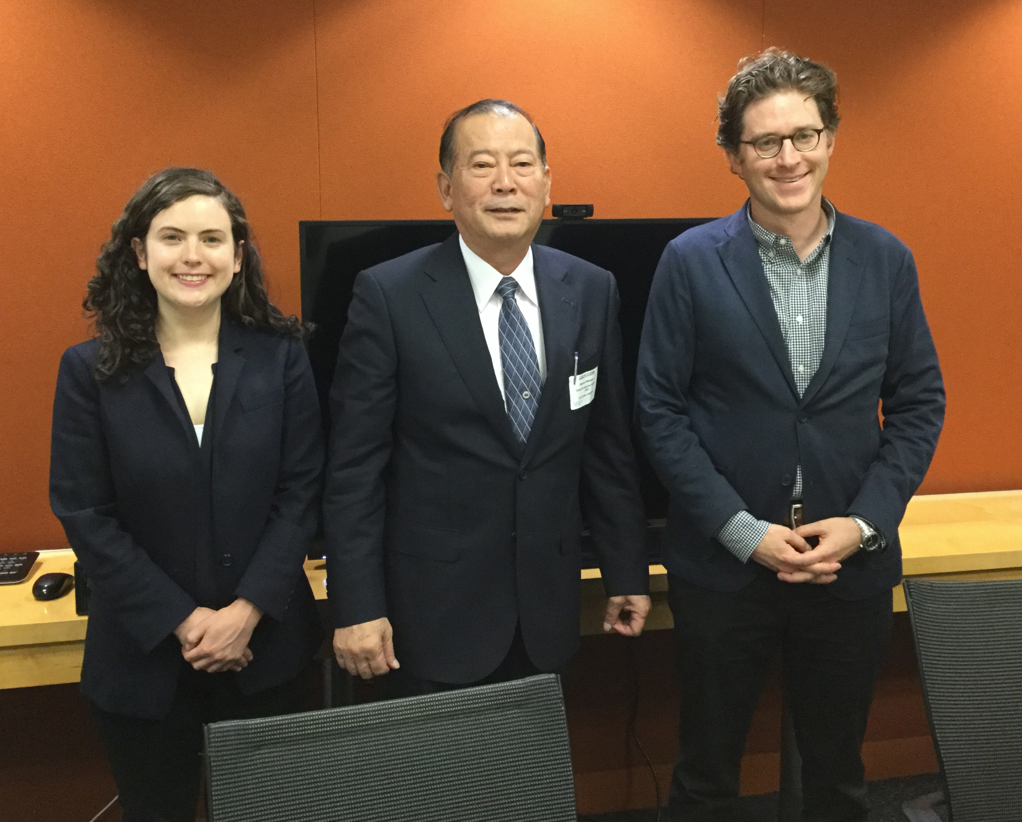日本人の男性を挟んで左側にアジア政策研究員の女性、右側に上級研究員の男性が一列に立っている写真