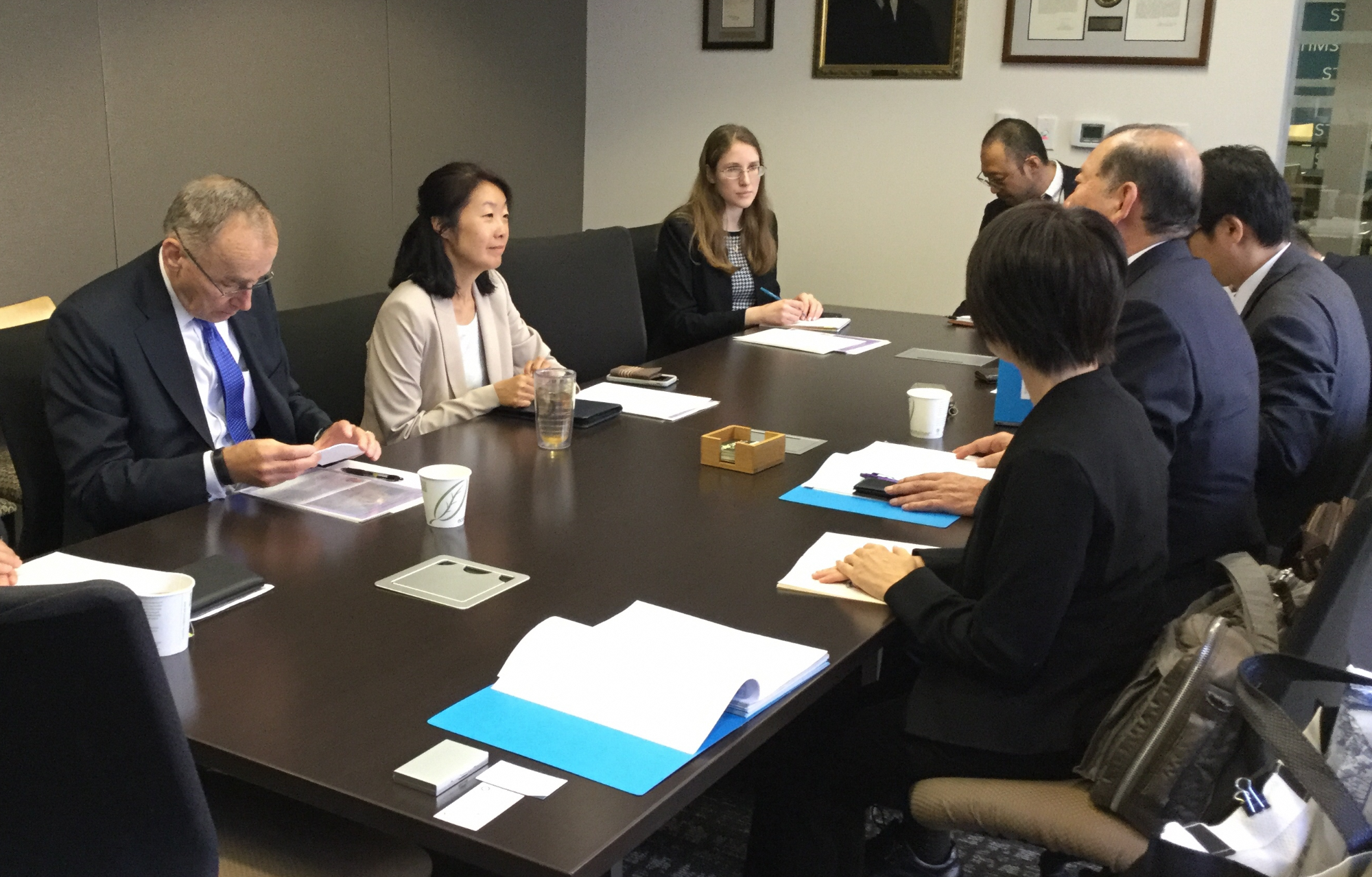 大きなテーブルを囲んで手前から日本人の女性1名と男性2名奥に1名、反対側に東アジア共同部長の日本人の女性とアメリカ人の男性1名と女性1名が話しをしている写真