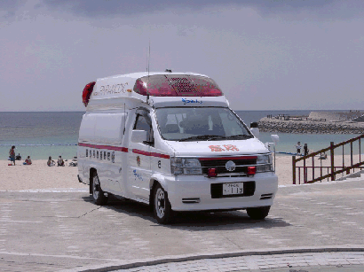 海岸沿いに白い救急車を左斜めから見た写真