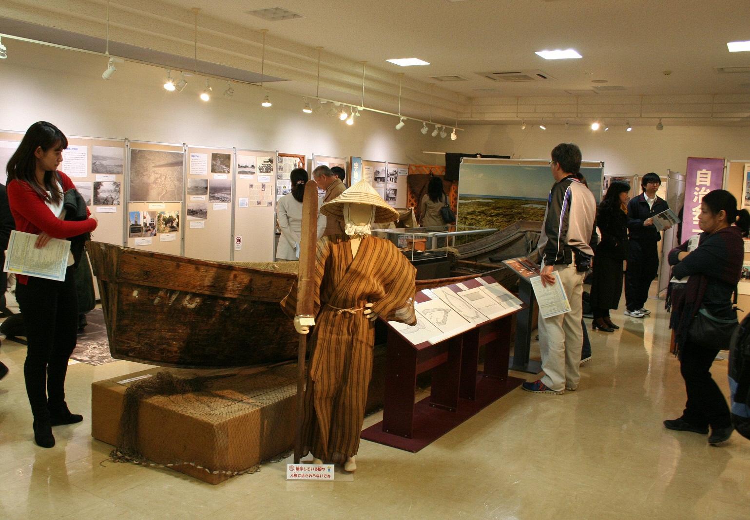 展示室の中央に大きな船と船をこぐ人の模型がある写真