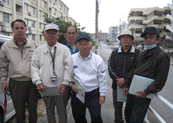 住宅地の中にある「大謝名駅」跡付近で6名の友の会の方々が記念撮影をしている写真