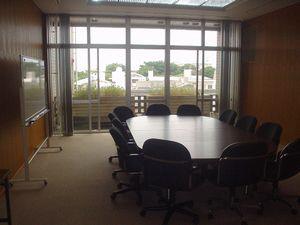 楕円形のテーブルとイスが設置された、会議室の写真